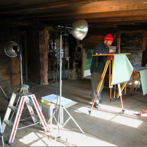 A staff member sketching a plan at the standing desk near the lamp