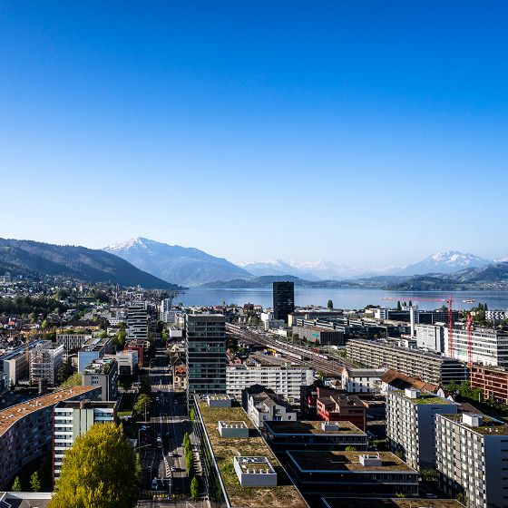 Luftbild von Zug bei blauem Himmel mit Sicht über die Neustadt Richtung See und Berge