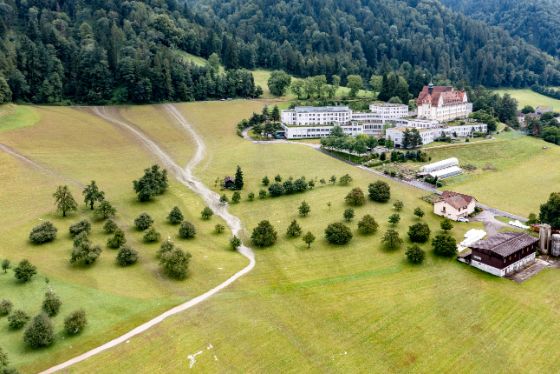 Wasser läuft neben der Klinik Zugersee vom Waldrand her über die Wiesen im Rüsli nach einem Gewitter am 25. Juli 2021