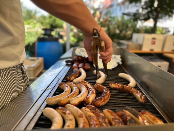Auf dem Grill liegen diverse Wurstspezialitäten, auch vegetarische, für die hungrigen Gäste bereit.