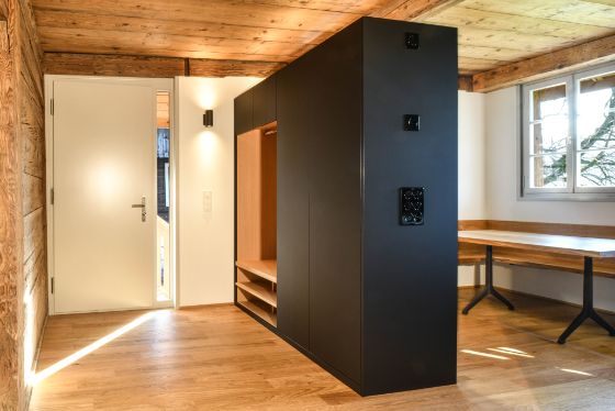 Wohnung im Hochparterre nach dem Umbau mit Tür, Tisch und Schrank in der Raummitte