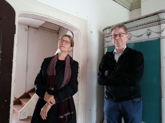 Karin Artho und Patrick Wahl vor blauem Kachelofen