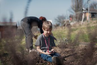 Frau und Junge spielen im Garten.