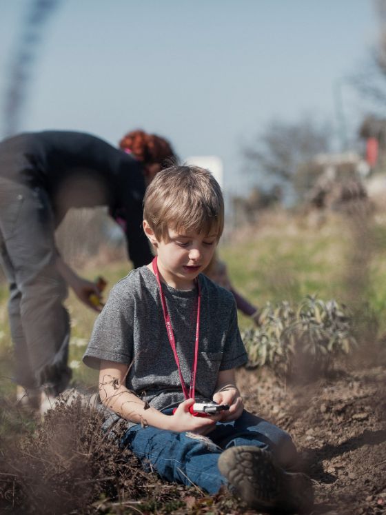 Frau und Junge spielen im Garten.