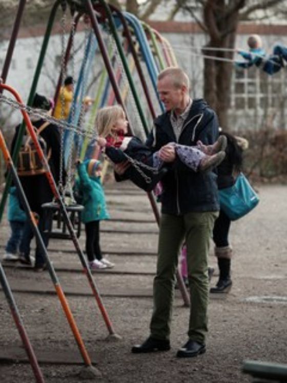 Mann und Kind spielen auf dem Spielplatz.