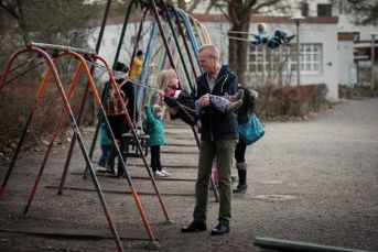 Mann und Kind spielen auf dem Spielplatz.