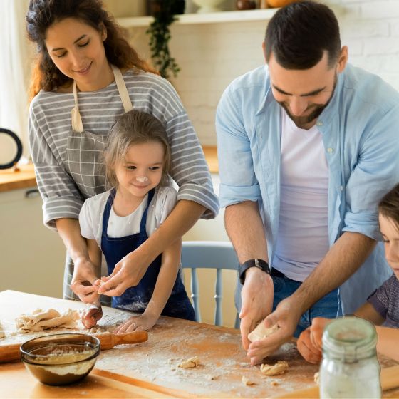 Eltern mit Kindern am Kekse backen