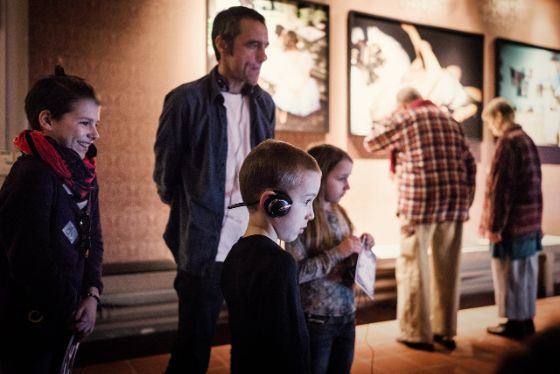 Mann mit drei Kindern im Museum. Sie begutachten die Ausstellung.